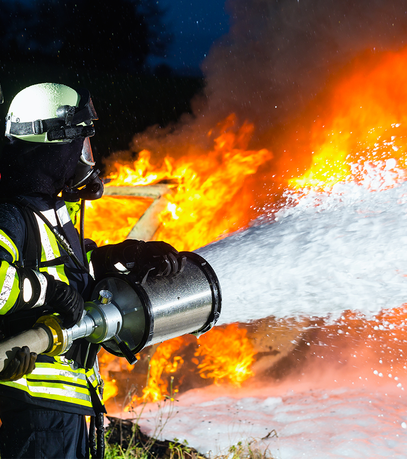 firefighter using foam to put out a fire